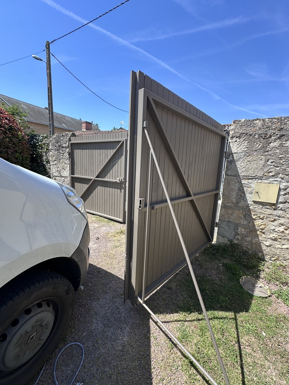 Portail en bois rénové et repeint en gris taupe après intervention en Deux-Sèvres